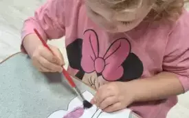 DZIEWCZYNKA MALUJE FARBAMI