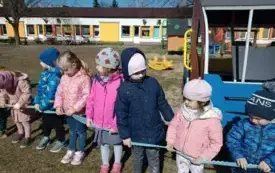 NA ZNAK SOLIDARNOŚCI Z OSOBAMI AUTYSTYCZNYMI PRZEDSZKOLAKI W OGRODZIE PRZEDSZKOLNYM UTWORZYŁY KOŁO, TRZYMAJĄC W RĘKACH NIEBIESKĄ WSTĄŻKĘ