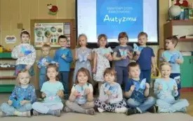 BIEDRONKI NA ZDJĘCIU GRUPOWYM. DZIECI TRZYMAJĄ W RĄCZKACH NIEBIESKIE MOTYLKI NA ZNAK SOLIDARNOŚCI Z OSOBAWI W SPEKTRUM AUTYZMU