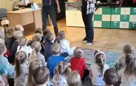 Dzieci słuchają prowadzących opowiadających o instrumentach, kt&oacute;re przynieśli
