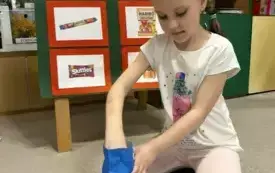 DZIEWCZYNKA ODMIERZA ZA POMOCA WAGI KUCHENNEJ ZAWARTOŚC CUKRU W PUSZCE PEPSI