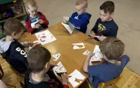 PRACA PRZY STOLIKU-DZIECI WYCINAJĄ ILUSTRACJĘ PRZEDSATWIAJĄCE PRODUKTY ŻYWNOŚCIOWE