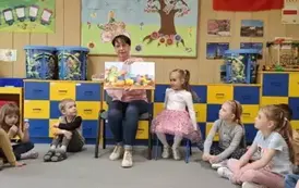 Babcia Gabrysi czyta dzieciom książkę 
