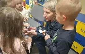 Mama Adama rozdaje dzieciom naklejki