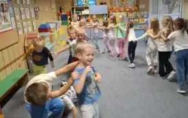 DZIECI USTWAIŁY SIĘ W POCIĄG I PORUSZAJĄ SIĘ W RYTM MUZYKI