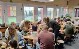 Dzieci i rodzice przygotowują razem deser