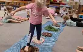 Dziecko przechodzi przez sensoryczną ścieżkę 