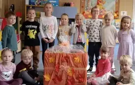 Reprezentacja dzieci z wszystkich grup przedszkolnych pozuje do zdjęcia z zebranymi herbatkami