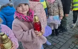 Dzieci stawiają znicze na grobach poległych żołnierzy
