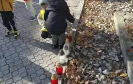 Dzieci stawiają znicze na grobach poległych żołnierzy