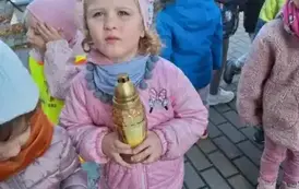 Dzieci stawiają znicze na grobach poległych żołnierzy