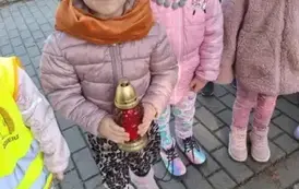 Dzieci stawiają znicze na grobach poległych żołnierzy