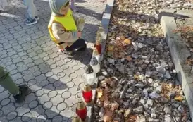 Dzieci stawiają znicze na grobach poległych żołnierzy