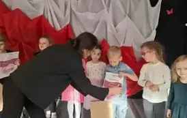 Prowadząca wręcza dyplom i nagrody