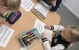 DZIECI PRACUJĄ PRZY STOLIKU - ZAMALOWUJĄ KOŁA WG WZORU