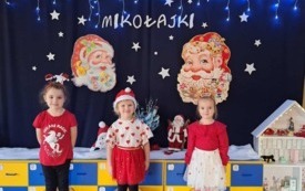 DZIECI POZUJĄ NA TLE ŚWIĄTECZNJ DEKORACJI