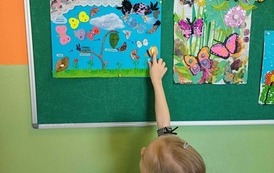 Dziewczynka pokazuje pracę plastyczną