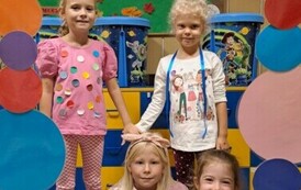 Dziewczynki z grupy zajączk&oacute;w pozują do zdjęcia w kropkowej foto budce