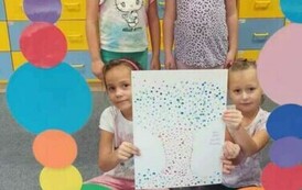 dziewczynki z grupy krasnali pozują do zdjęcia w kropkowej foto budce