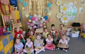 grupa krasnali pozuje przy ściance fotobudkowej