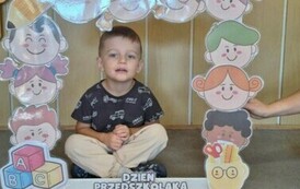 chłopiec z grupy motylk&oacute;w pozuje w fotobudce