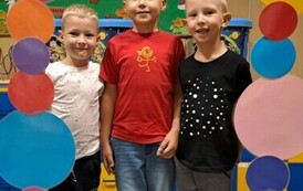 Grupa chłopc&oacute;w pozuje w foto budce z k&oacute;łek 