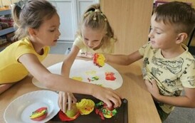 dzieci z grupy starszak&oacute;w robią prace plastyczną przy pomocy jabłkowych stempli 