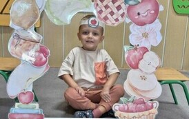 chłopiec z grupy motylk&oacute;w uśmiecha się do zdjęcia w fotobudce