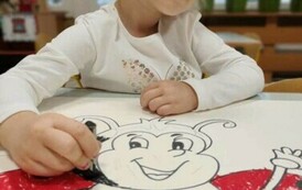 Dziewczynka koloruje szablon biedronki