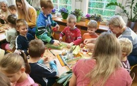 Dzieci z rodzicami podczas tworzenia ludzik&oacute;w z warzyw