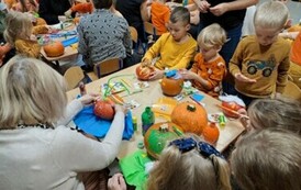 Rodzice z dziećmi tworzą dyniowe stworki 