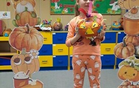 Dziewczynka pozuje do zdjęcia w dyniowej foto budce