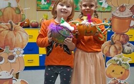 Dziewczynki pozują do zdjęcia w dyniowej foto budce