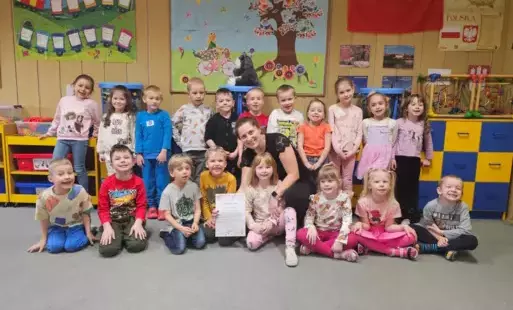 Dzieci pozują do zdjęcia z prowadzącą warsztaty mamą