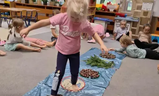 Dziecko przechodzi przez sensoryczną ścieżkę 