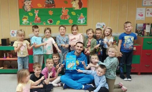 dzieci z grupy Krasnali pozują do wspólnego zdjęcia z Panem Michałem podczas wspólnego czytania 